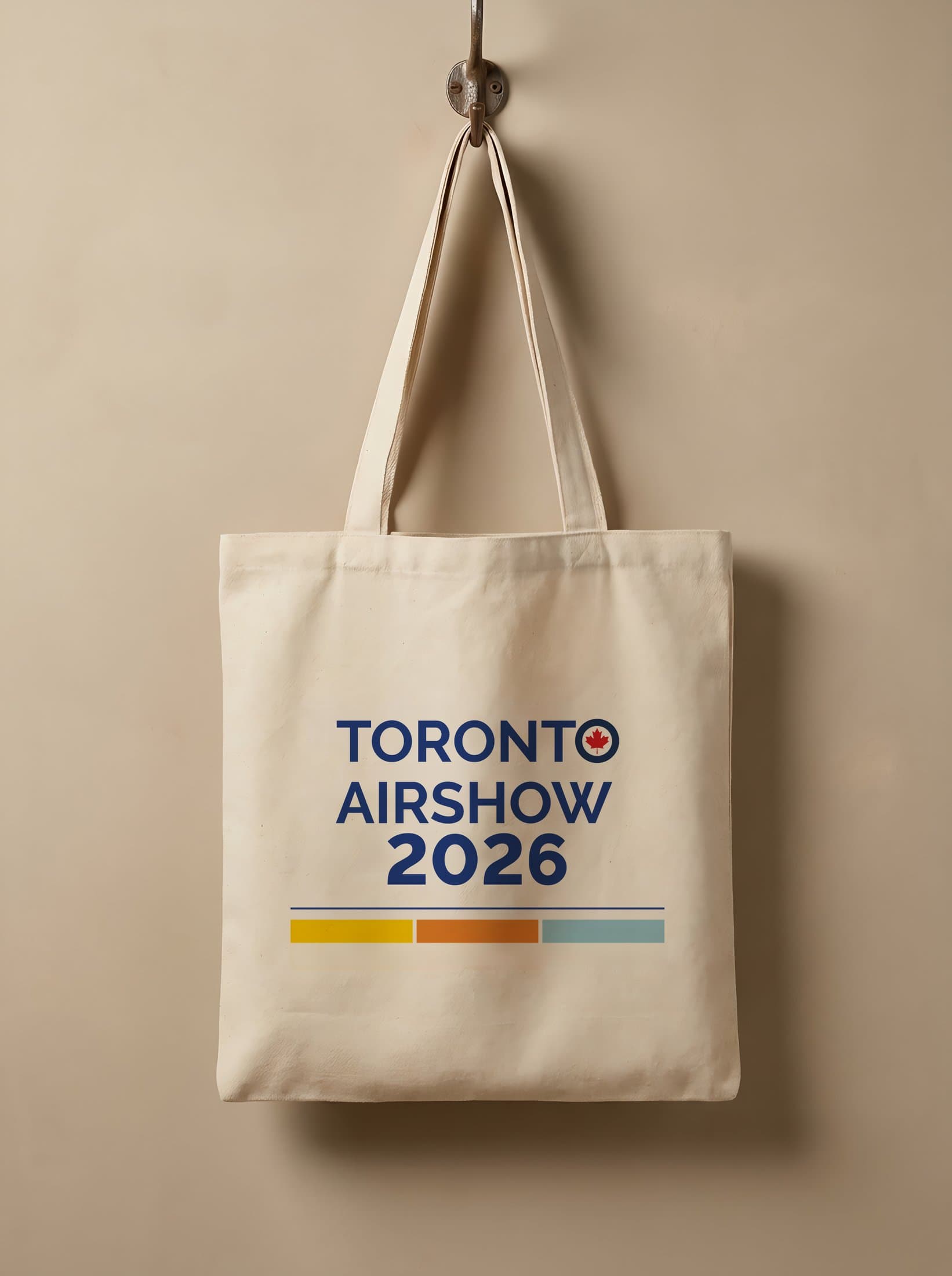 Canvas tote — the wordmark re-set for 2026 with the three-colour bar, centred on the bag